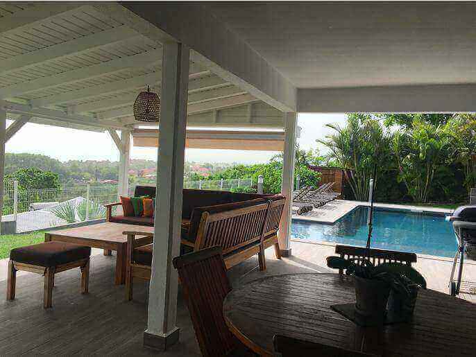 Location VillaMaison en Guadeloupe - Ct terrasse couverte de 50m2 avec carrelage anti-drapant vue sur la piscine et la mer
